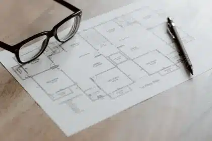 Anonimowe postacie w sprzęcie taktycznym planujące napad przy stole z mapami i dokumentami