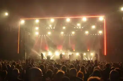 Koncert na scenie z publicznością, dynamiczne oświetlenie, energiczna atmosfera