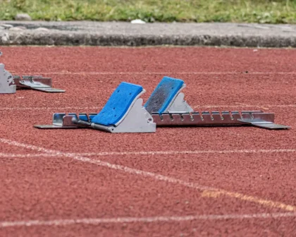 Sprinterka na torze lekkoatletycznym w pozycji startowej, tuż przed wystrzeleniem