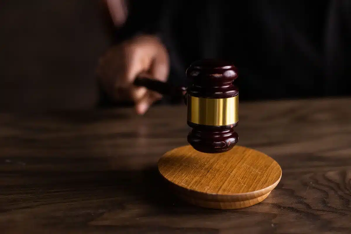 Sędzia w todze trzymający młotek sądowy w sali rozpraw