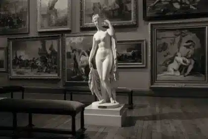 Odwiedzający oglądają wystawy sztuki figuratywnej w nowoczesnej galerii