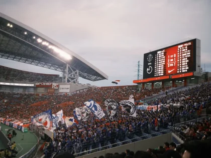 Rozczarowana publiczność na stadionie piłkarskim, widoczne napięcie i frustracja kibiców.