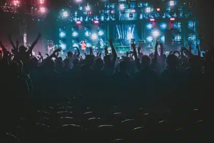 Tłum przed rozświetloną sceną w dużej hali koncertowej