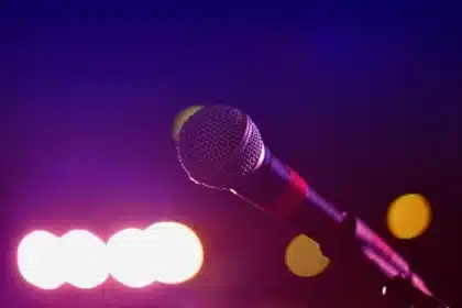 Sylwetki widzów i mikrofon na scenie w klubie koncertowym