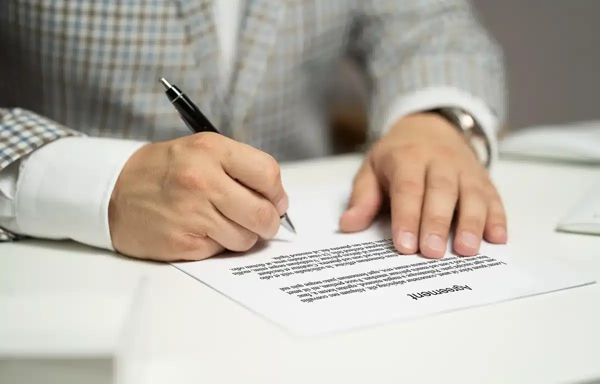 Anonimowe ręce przekazujące kopertę nad dokumentami i mapą regionu