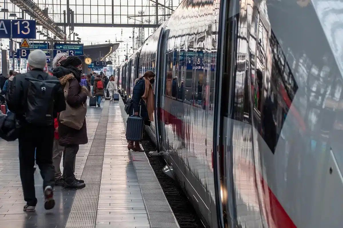 Pociąg na peronie z tablicą informującą o opóźnieniach