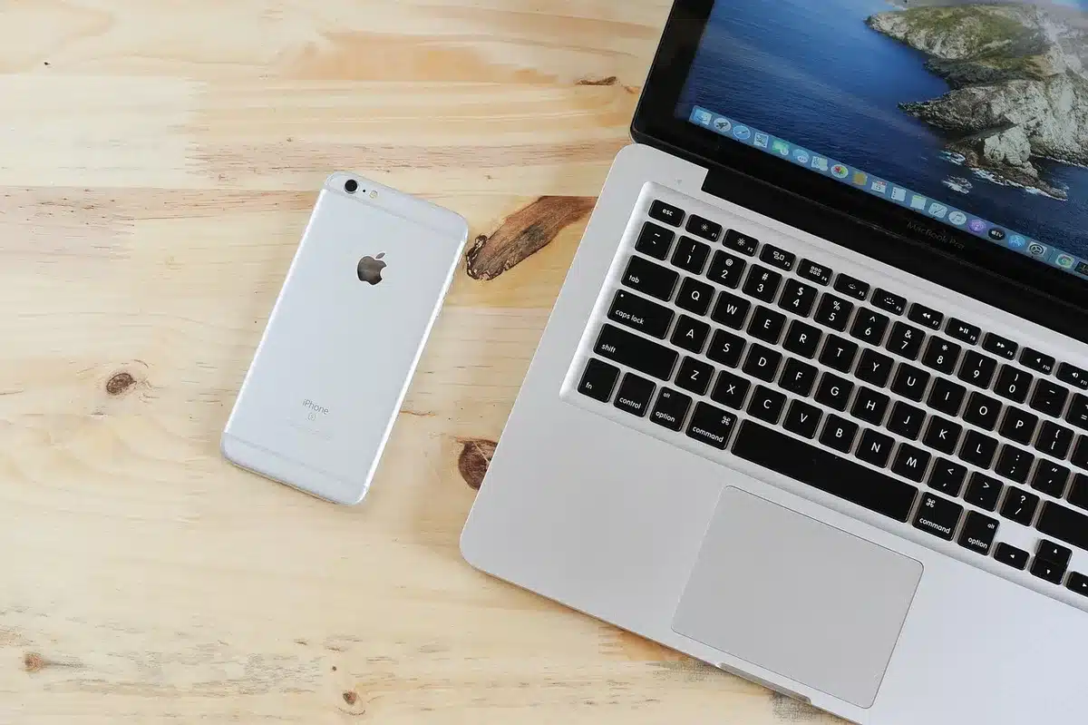 Podróżnik planuje wyjazd na laptopie i smartfonie z inspiracjami z destynacji na ekranie