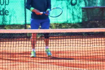 Zbliżenie na anonimową zawodniczkę sięgającą po backhand na korcie tenisowym