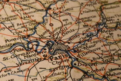 Sylwetki osób przy stole z mapą Europy i modelem parlamentu, symbol debaty politycznej