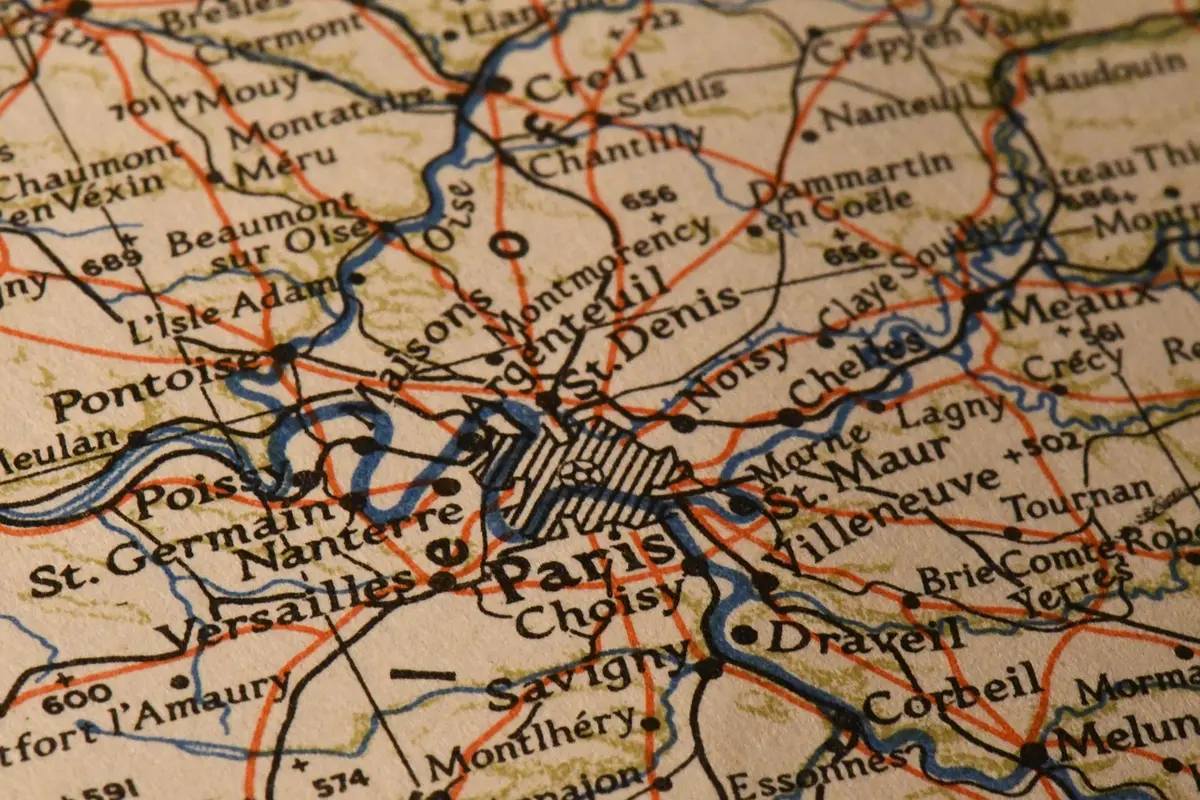 Sylwetki osób przy stole z mapą Europy i modelem parlamentu, symbol debaty politycznej