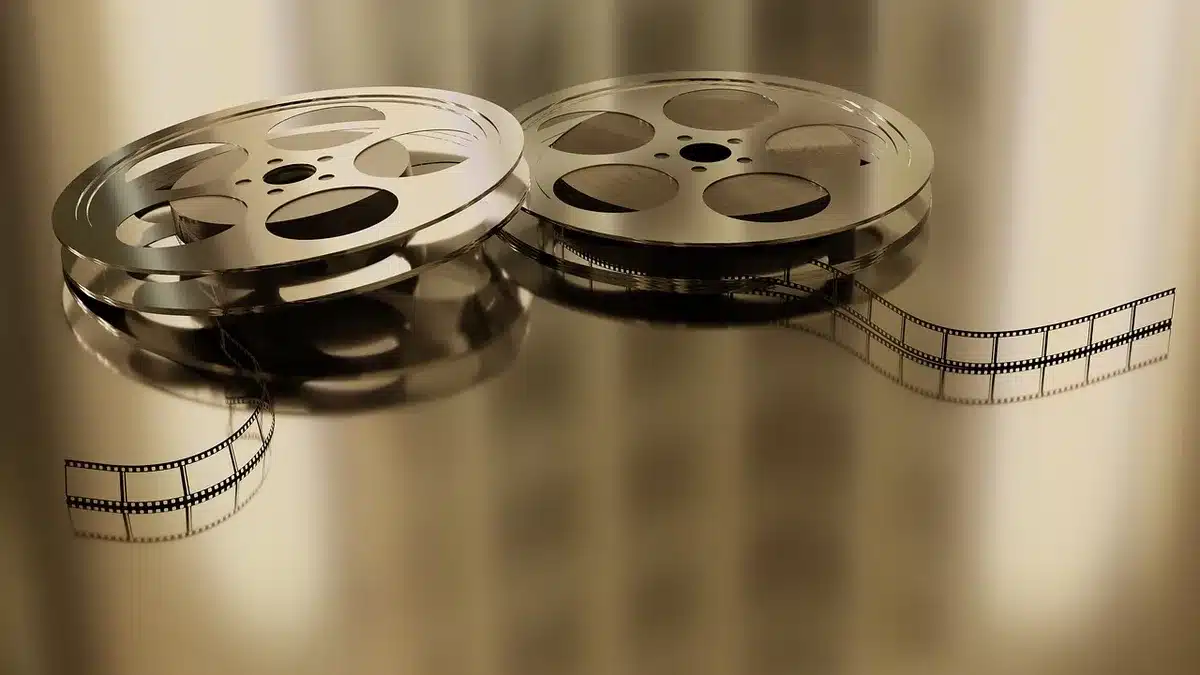 Stary projektor filmowy rzucający światło w ciemnym kinie — symbol dziedzictwa kinematografii grozy