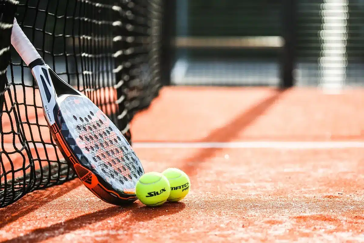 Korytarz hali sportowej z rozłożonym sprzętem i sylwetkami kibiców