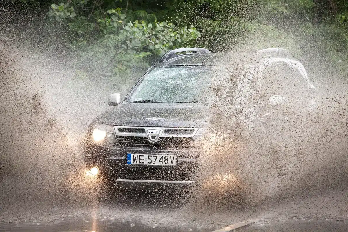 Rodzina odbiera biały SUV zaparkowany na podjeździe, anonimowe sylwetki
