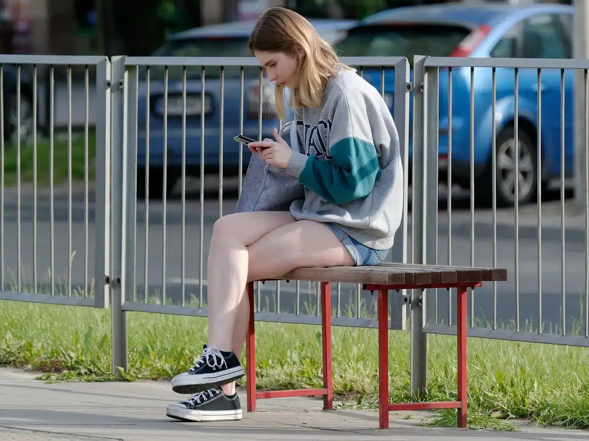 Ręka trzymająca telefon z wynikami wyszukiwania seriali na platformie