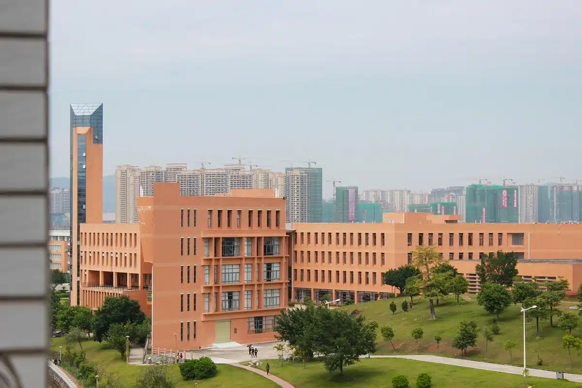 Wejście na kampus uczelni z zamkniętą bramą i pustym placem