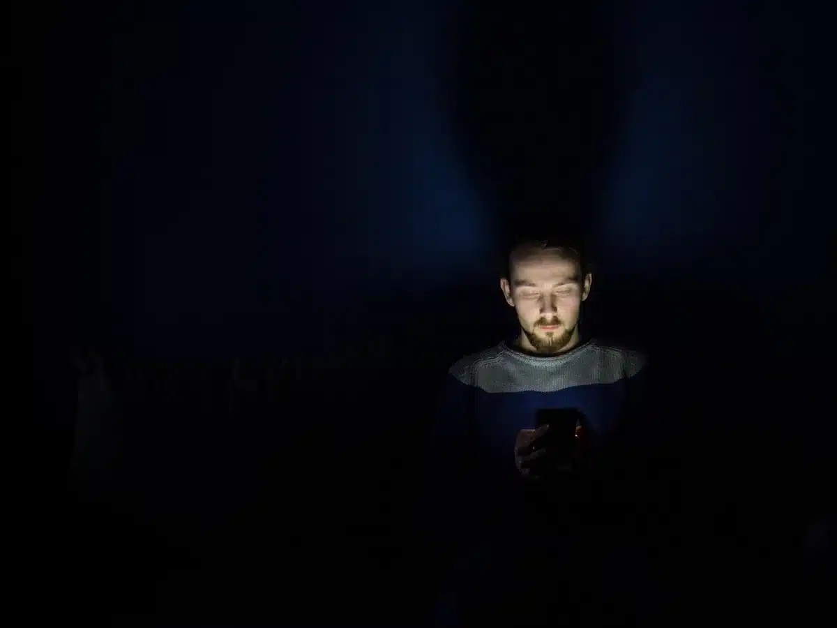 Ręce trzymające smartfon z otwartą aplikacją społecznościową, bez widocznych twarzy