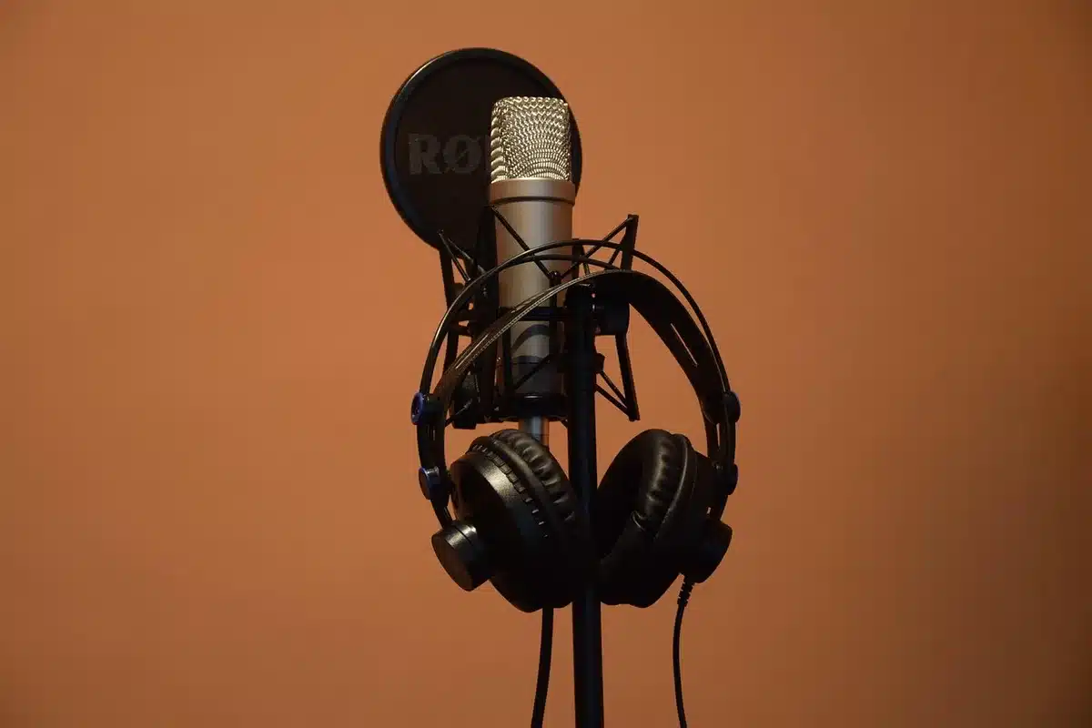 Dwóch dziennikarzy rozmawia w studiu podcastowym o trenerze i jego kryzysie
